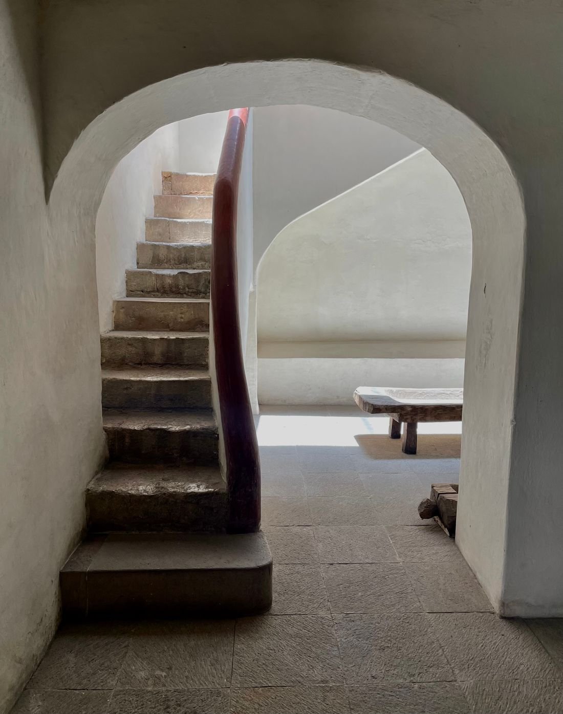 A sunlit arch and richly textured stone staircase